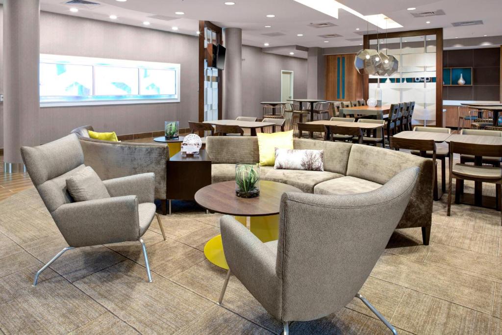 雷内克萨SpringHill Suites by Marriott Kansas City Lenexa/City Center的大堂配有沙发和桌子,并设有餐厅。