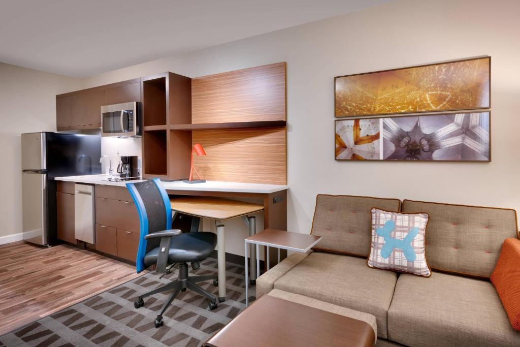 德雷珀TownePlace Suites by Marriott Salt Lake City Draper的带沙发和书桌的客厅以及厨房。