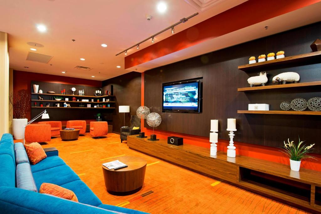 渥太华Courtyard by Marriott Ottawa East的客厅配有蓝色的沙发和电视