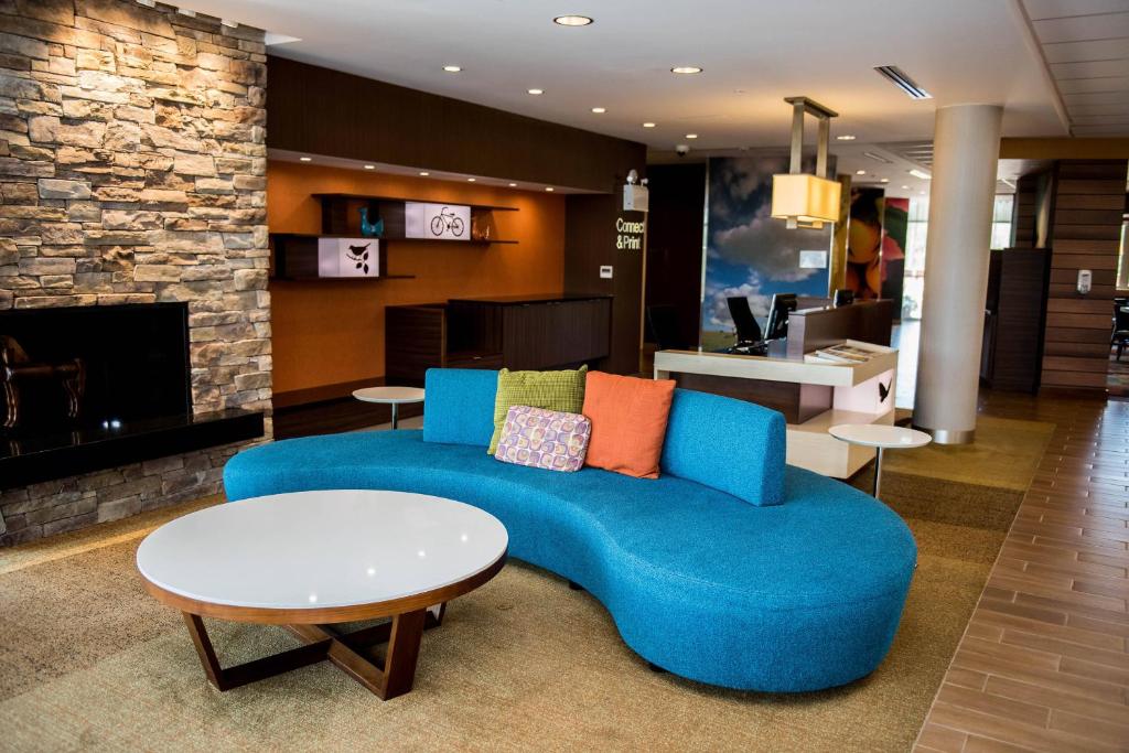 蒙克顿Fairfield Inn & Suites by Marriott Moncton的客厅设有蓝色的沙发和壁炉