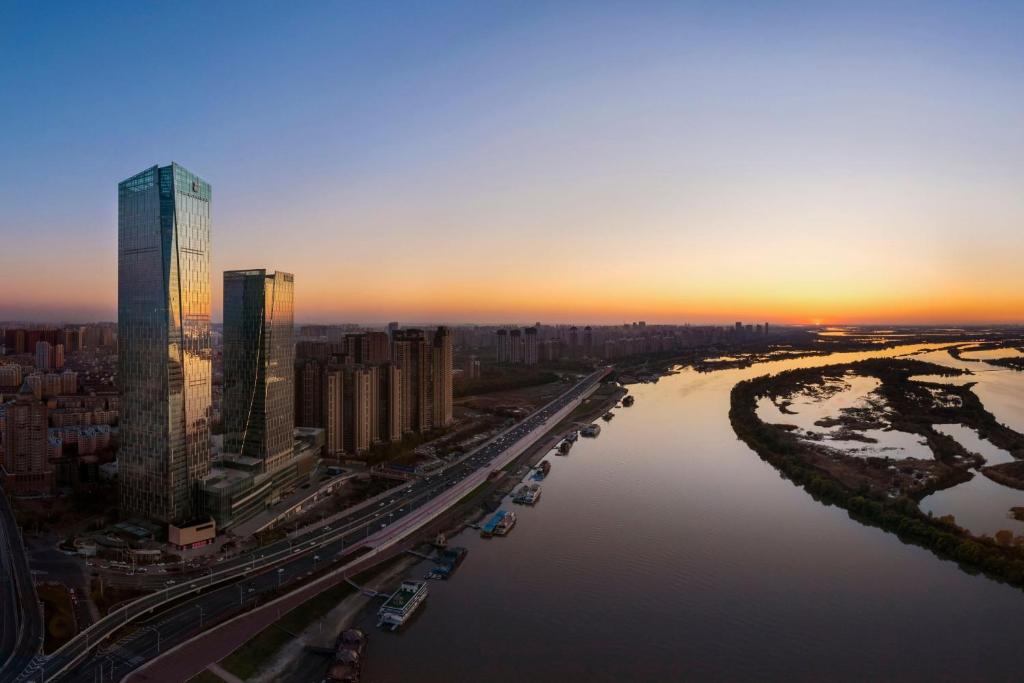 哈尔滨哈尔滨富力丽思卡尔顿酒店的享有河流和建筑的城市空中景致