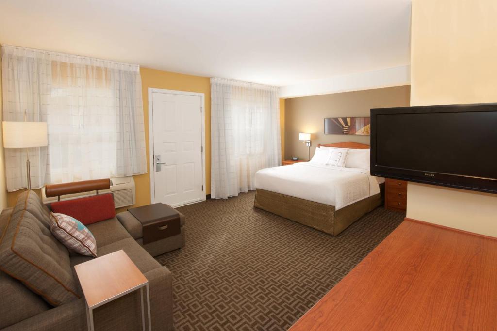 马科尔蒂奥西雅图埃弗里特/马基尔提奥万豪广场套房酒店的配有一张床和一台平面电视的酒店客房
