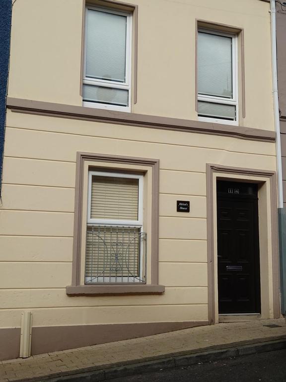 伦敦德里Helens House Derry City Centre Remarkable 3-Bed的一座带两扇窗户和一扇门的建筑