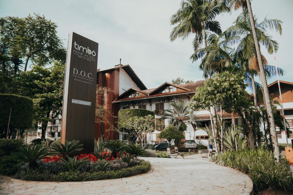 廷博天宝园酒店的棕榈树建筑前的标志