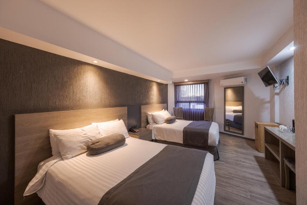 瓜达拉哈拉马里布酒店的酒店客房设有两张床和盥洗盆