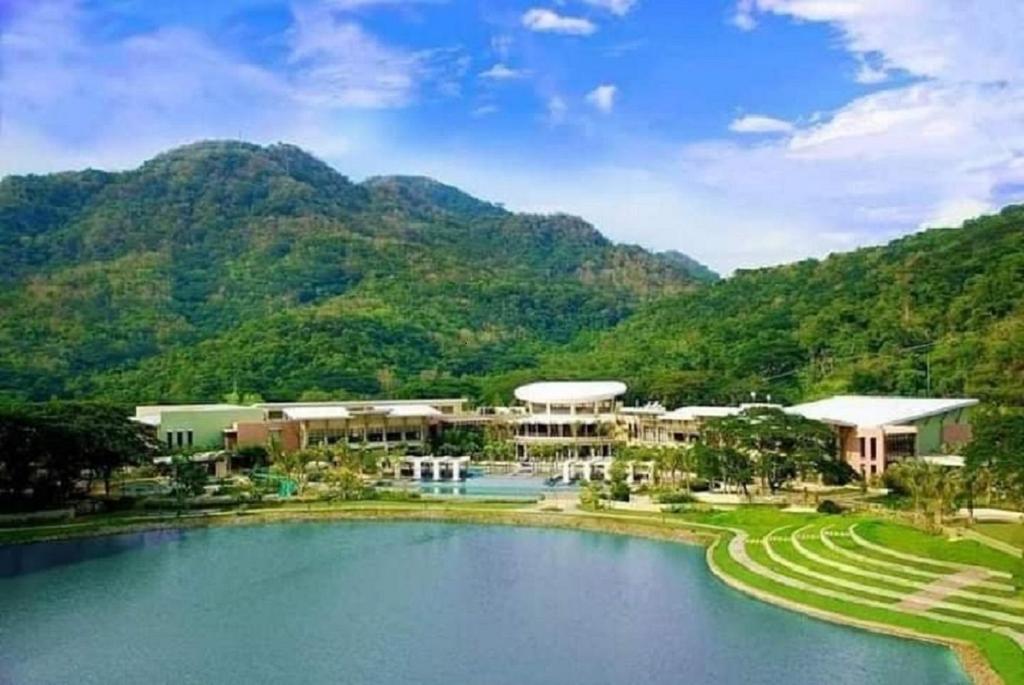 CutadPico De Loro Hamilo Coast beach and Country Club - Myna B One Bedroom的山前带游泳池的度假胜地