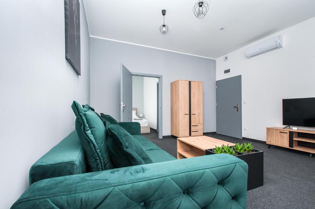 格利维采Apartamenty Zabrska 45的客厅配有绿色沙发和电视