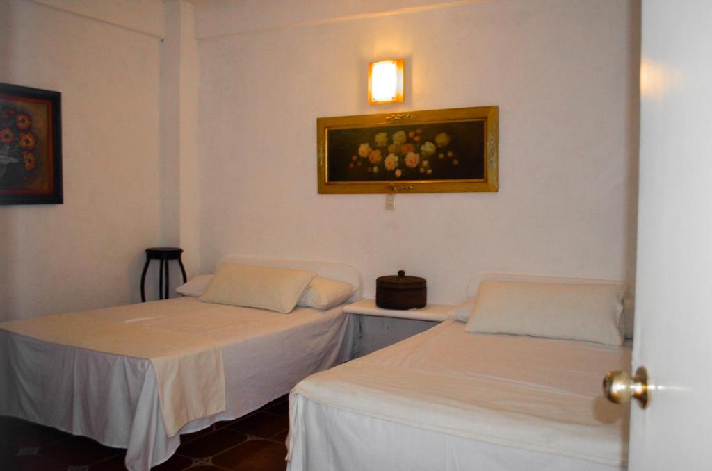 特科卢特拉Posada Casa Antigua的墙上有两张照片的房间
