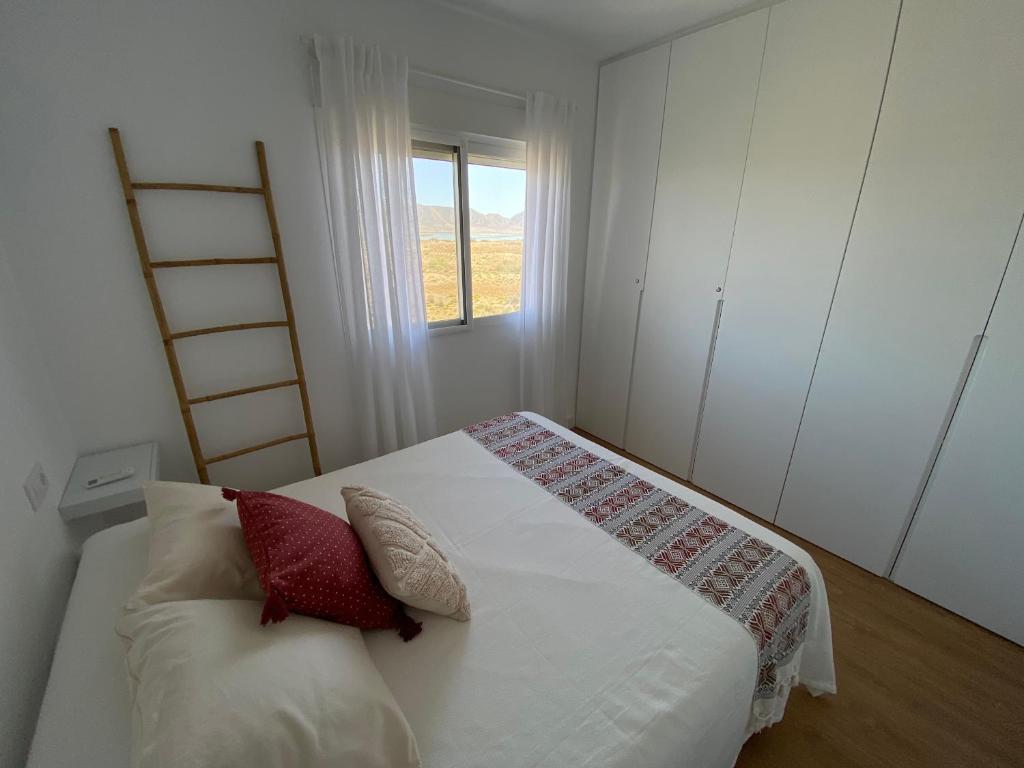 埃尔卡沃德加塔Tu casa en El Cabo的一间卧室配有带两个枕头的床和窗户