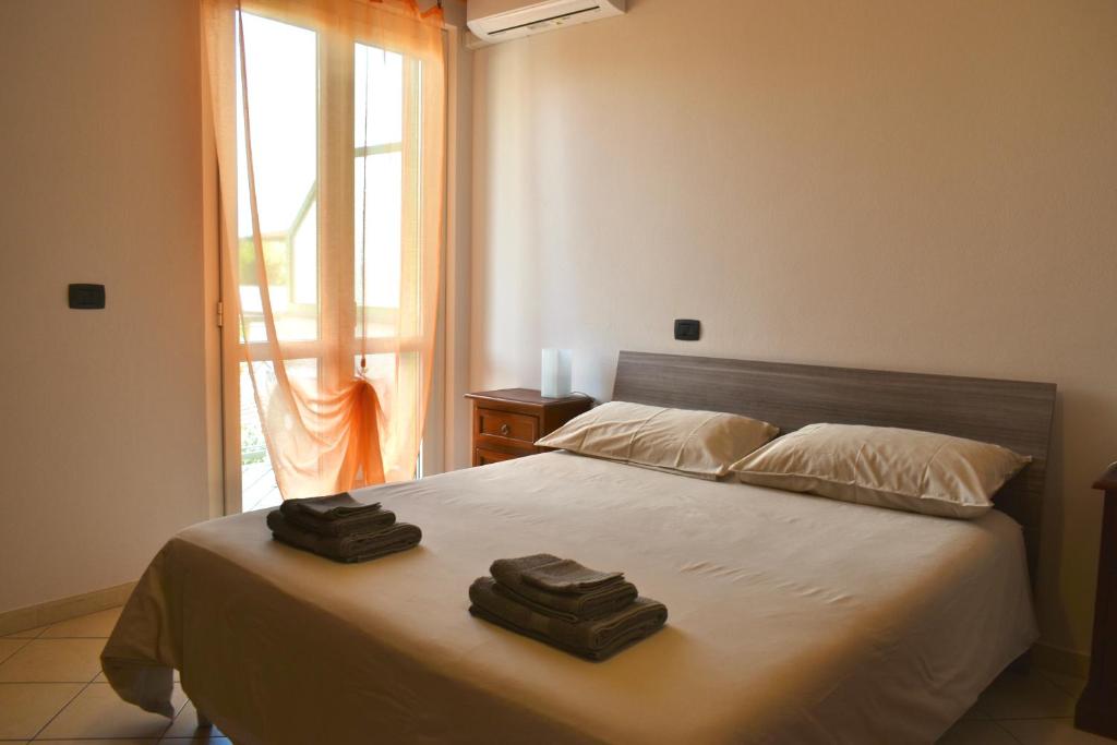 马里纳迪马萨Orange Apartment的一间卧室配有一张床,上面有两条毛巾