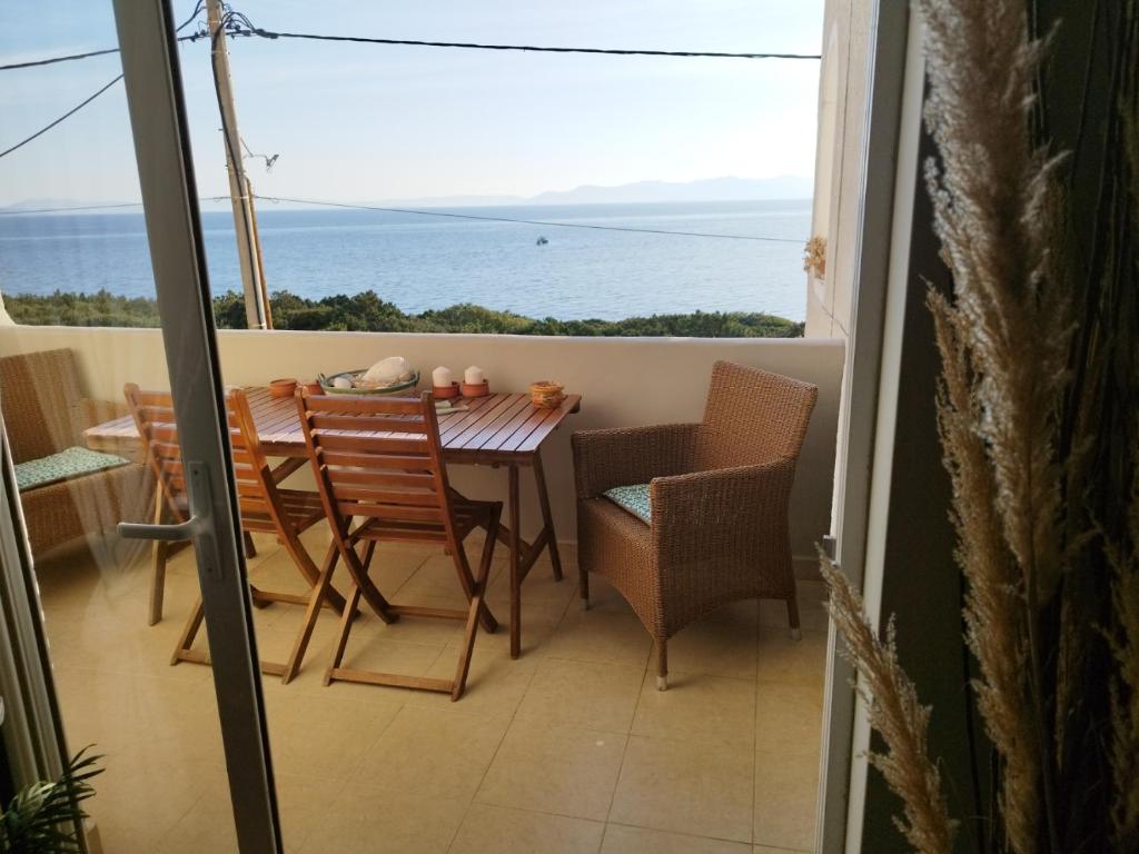 拉斐那Indigo的阳台配有桌椅,享有海景。