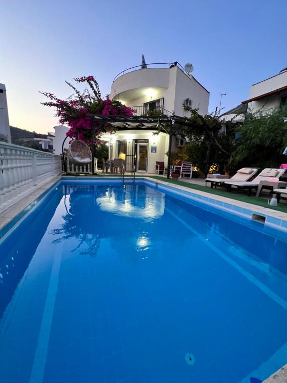 卡尔坎Entire Villa Lulu Kalkan - Private Pool, free Wi-Fi, Good Location, Breathtaking Sea Views的一座大蓝色游泳池,位于房子前