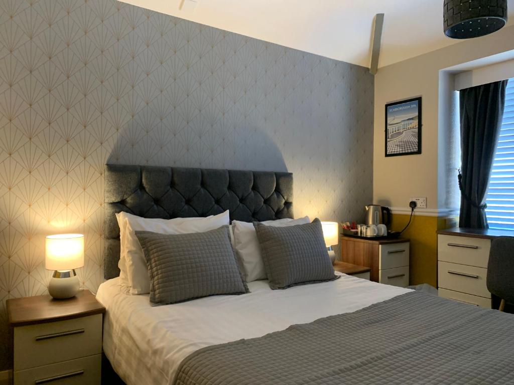 斯卡伯勒The Headlands Hotel的一间卧室配有一张大床和床头板