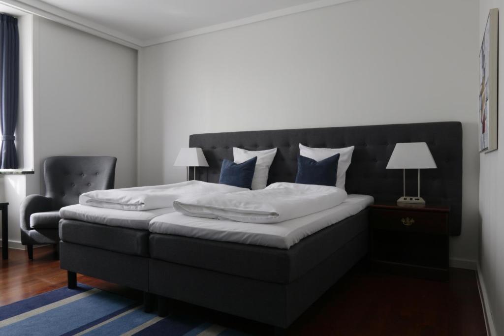 奥尔堡赫尔南凤凰酒店的一间卧室配有一张带蓝色枕头的大床