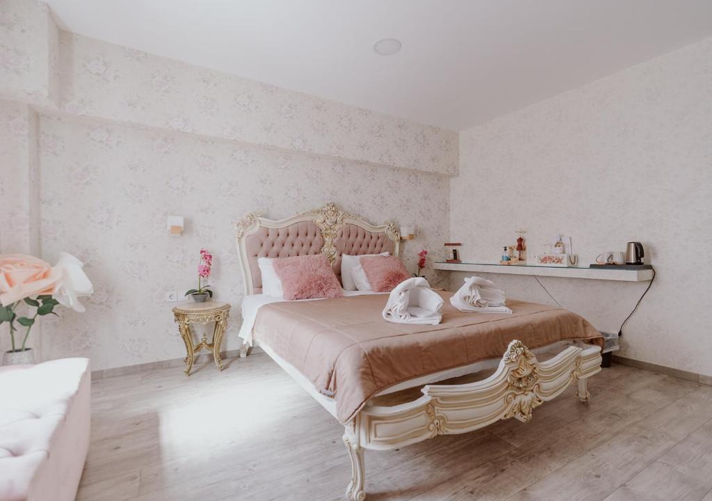 雅典ROH Suites的白色卧室配有带粉红色枕头的大床