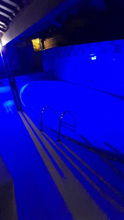 皮帕Pelados Beach Hostel的暗室里带蓝色灯光的游泳池