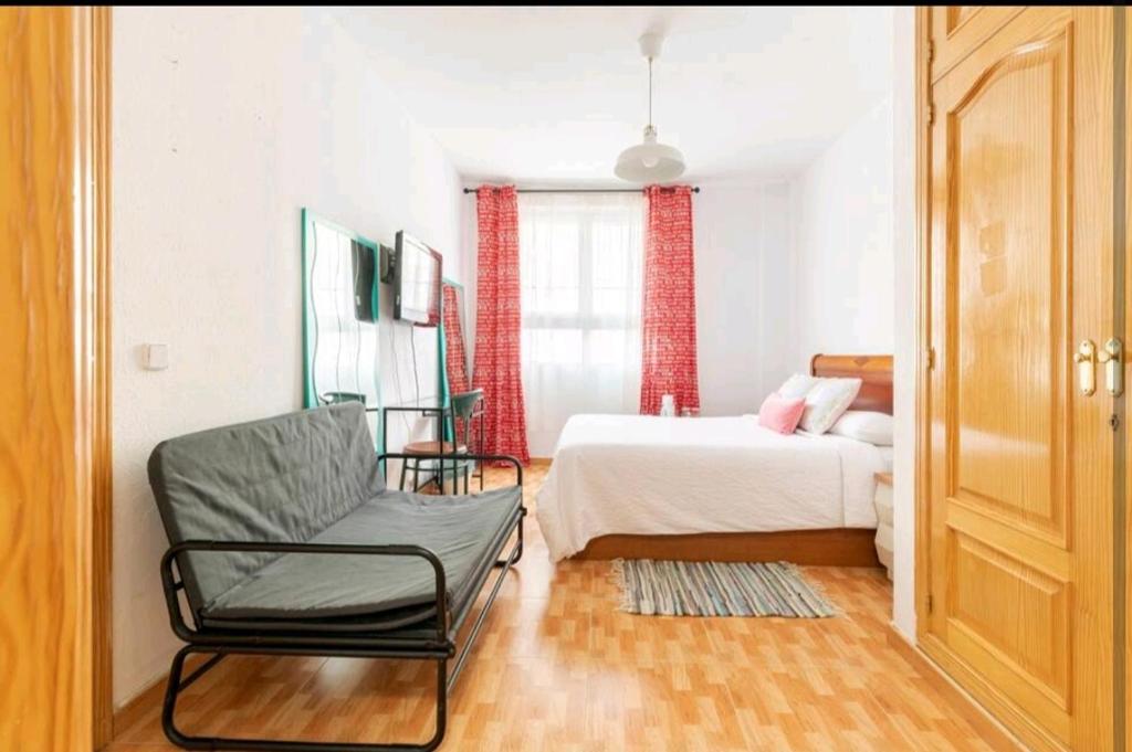 马德里Acogedora Habitación en Madrid的一间卧室配有一张床和一把椅子