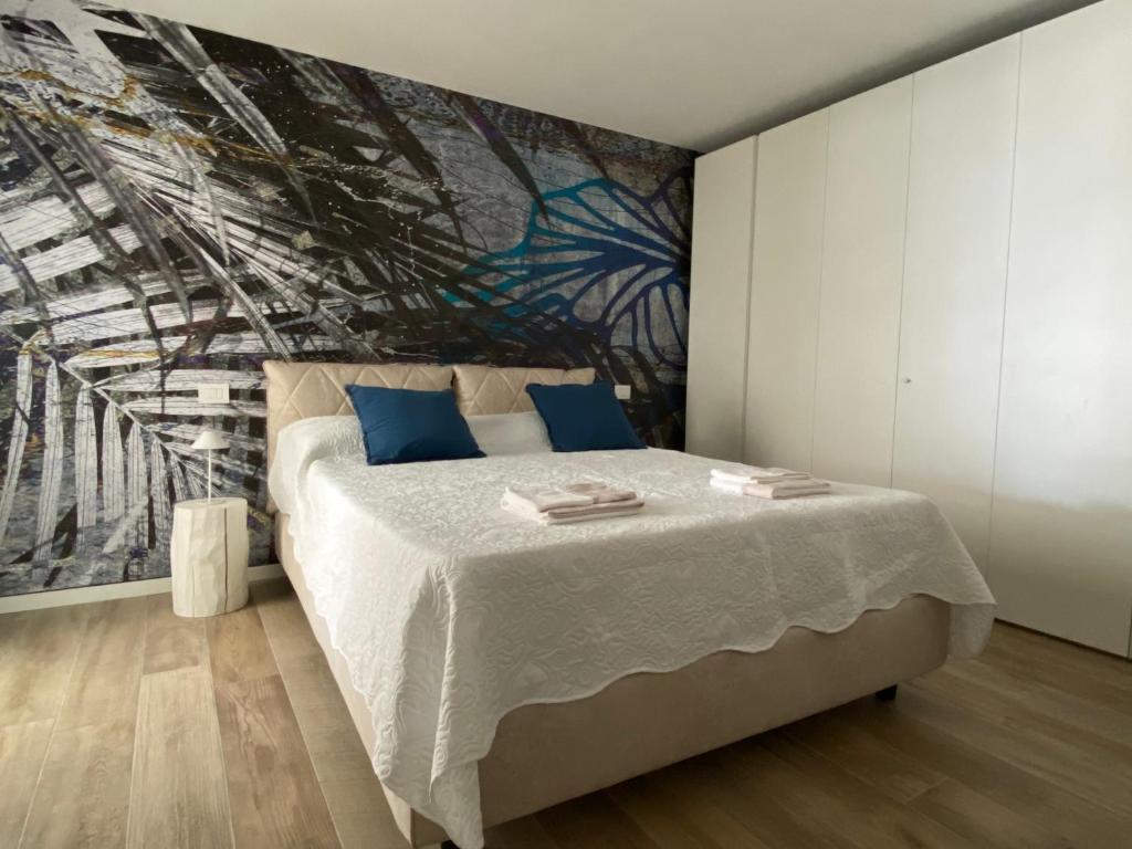 利尼亚诺萨比亚多罗BOUTIQUE HOME LIGNANO的一间卧室配有一张壁画床
