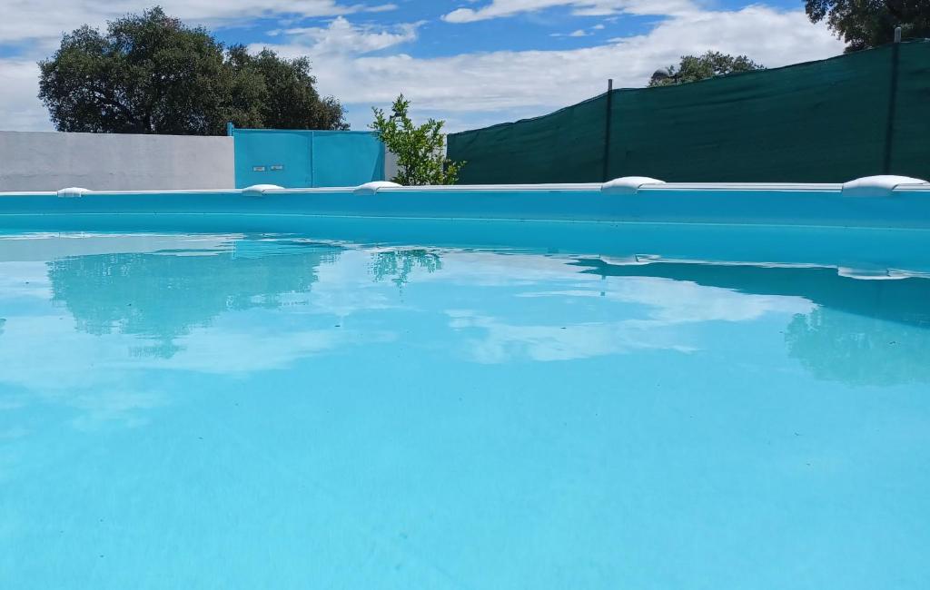 埃尔卡斯蒂略德拉斯瓜尔达斯Villa Saudade, casa entre encinas的 ⁇ 前的蓝色海水游泳池