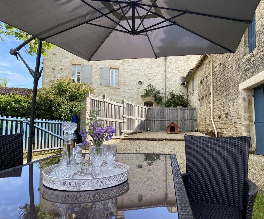 MerventGîte du Rossignol entre lac et forêt的露台上的桌子和遮阳伞