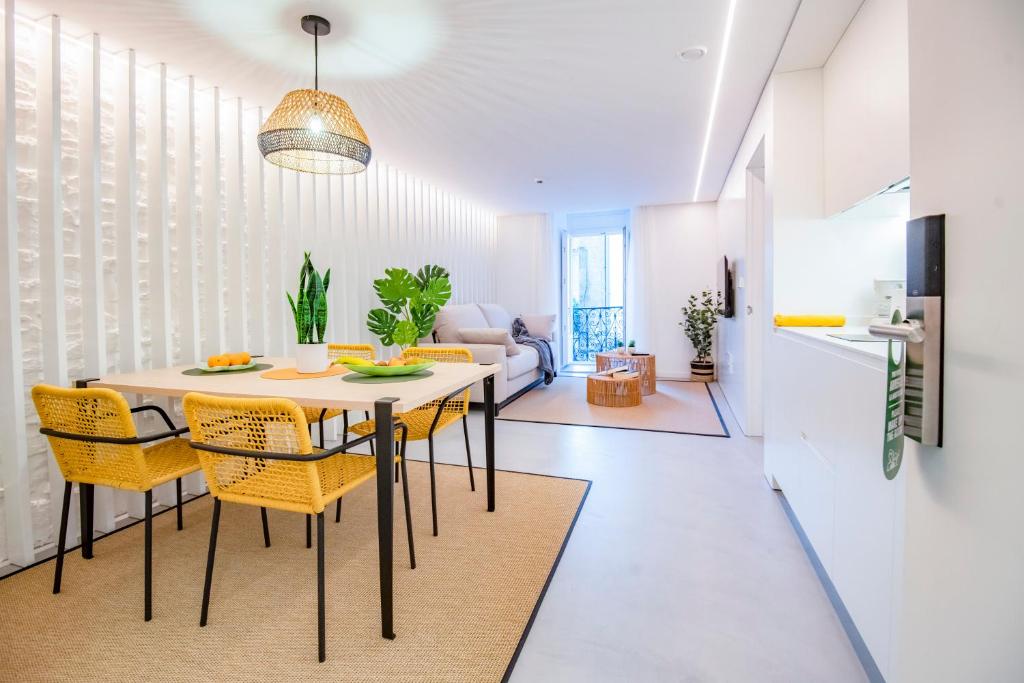 圣地亚哥－德孔波斯特拉Apartamentos Atia Catedral的一间带桌子和黄色椅子的用餐室
