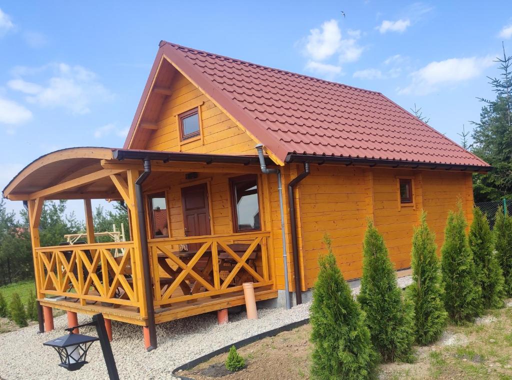 雷恩Domki z bali u Ireny Mazury的一间设有红色屋顶的小木屋