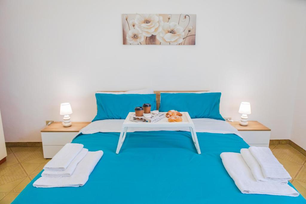巴科利LE CAMERELLE的一间卧室配有一张蓝色的床,上面有托盘