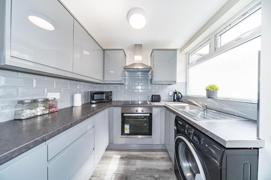 利物浦Hosted By Ryan - Huge 4 Bedroom House的厨房配有白色橱柜、洗衣机和烘干机