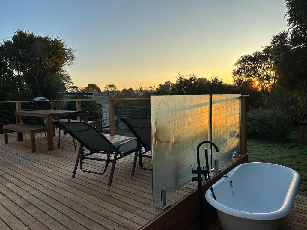 克莱斯韦克Enjoy a renovated retreat with outdoor bath的木制甲板配有浴缸和桌子
