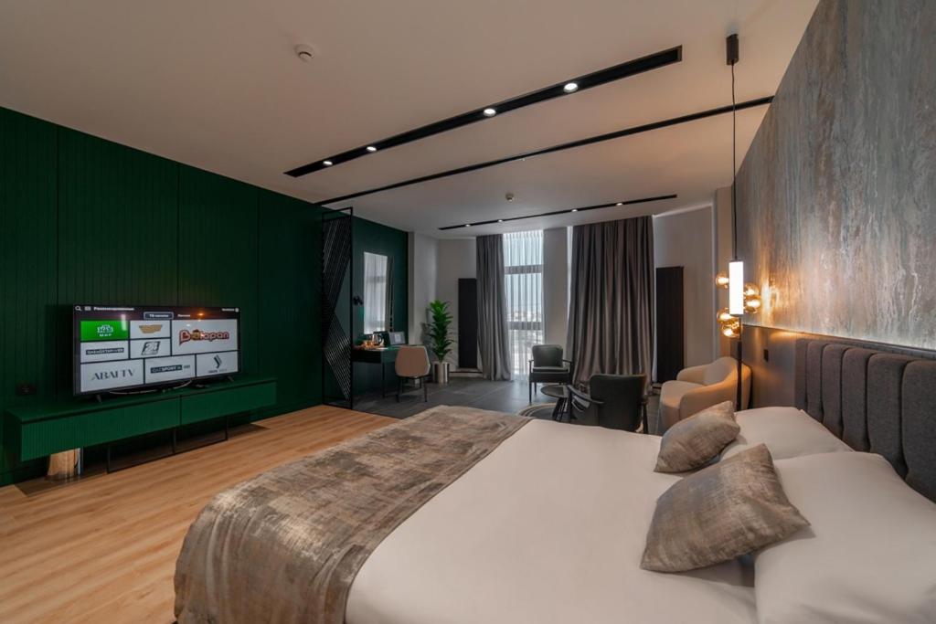 阿克套Dostyk Business Hotel的一间卧室配有一张大床和一台平面电视