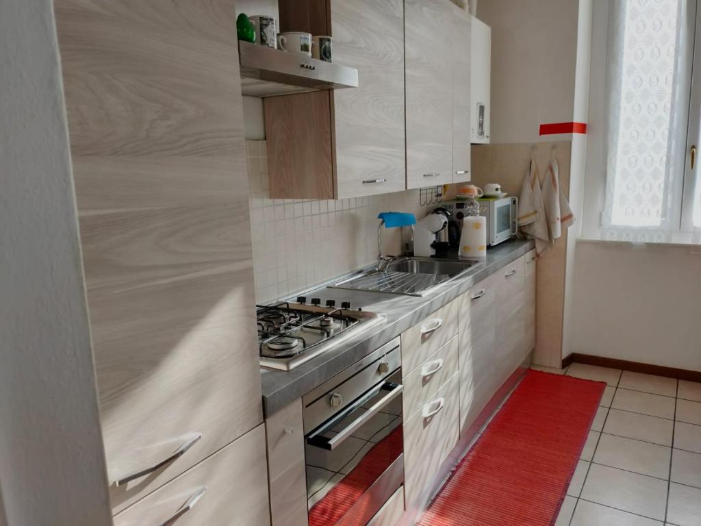 MalnateB&B Villa Hope的厨房配有白色橱柜和炉灶烤箱。