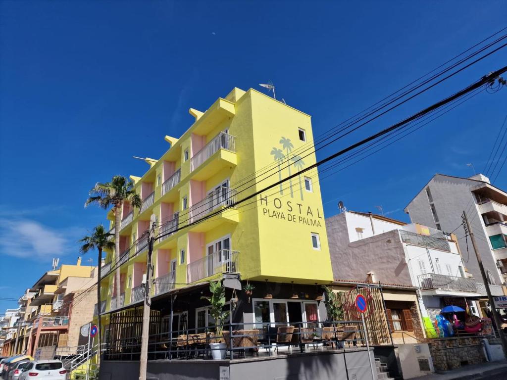 帕尔马海滩巴利阿里群岛旅馆的黄色的建筑,旁边是酒店