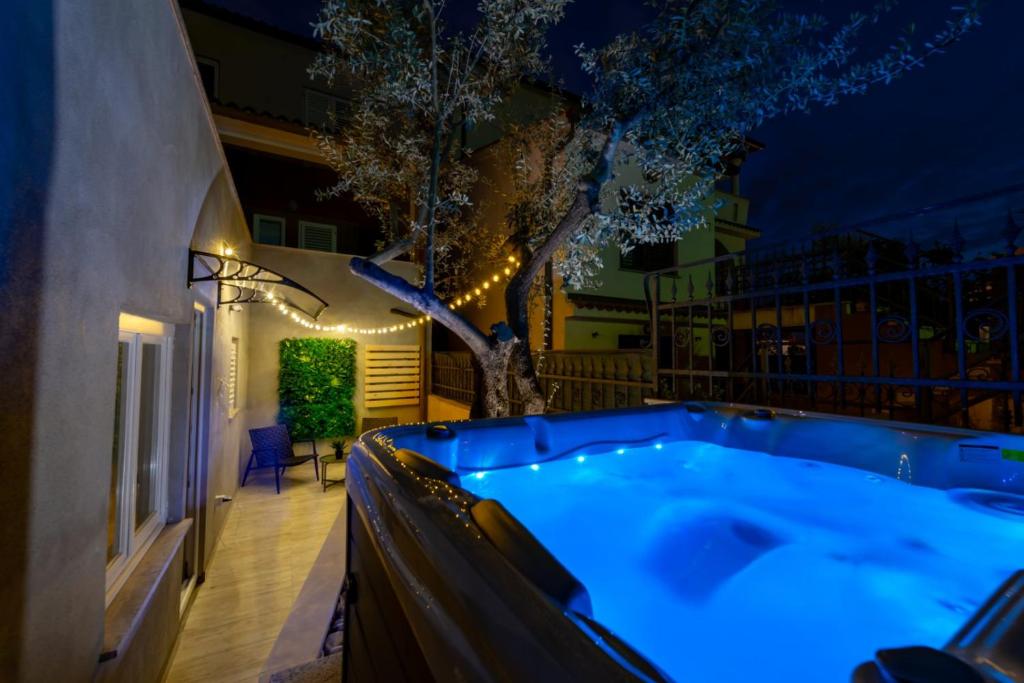 温克兰Studio Apartment Mare with private garden and jacuzzi的晚上在后院的热水浴池