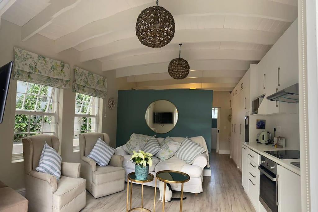 开普敦Gorgeous, private cottage in prestigious Newlands.的客厅配有白色的沙发和桌子