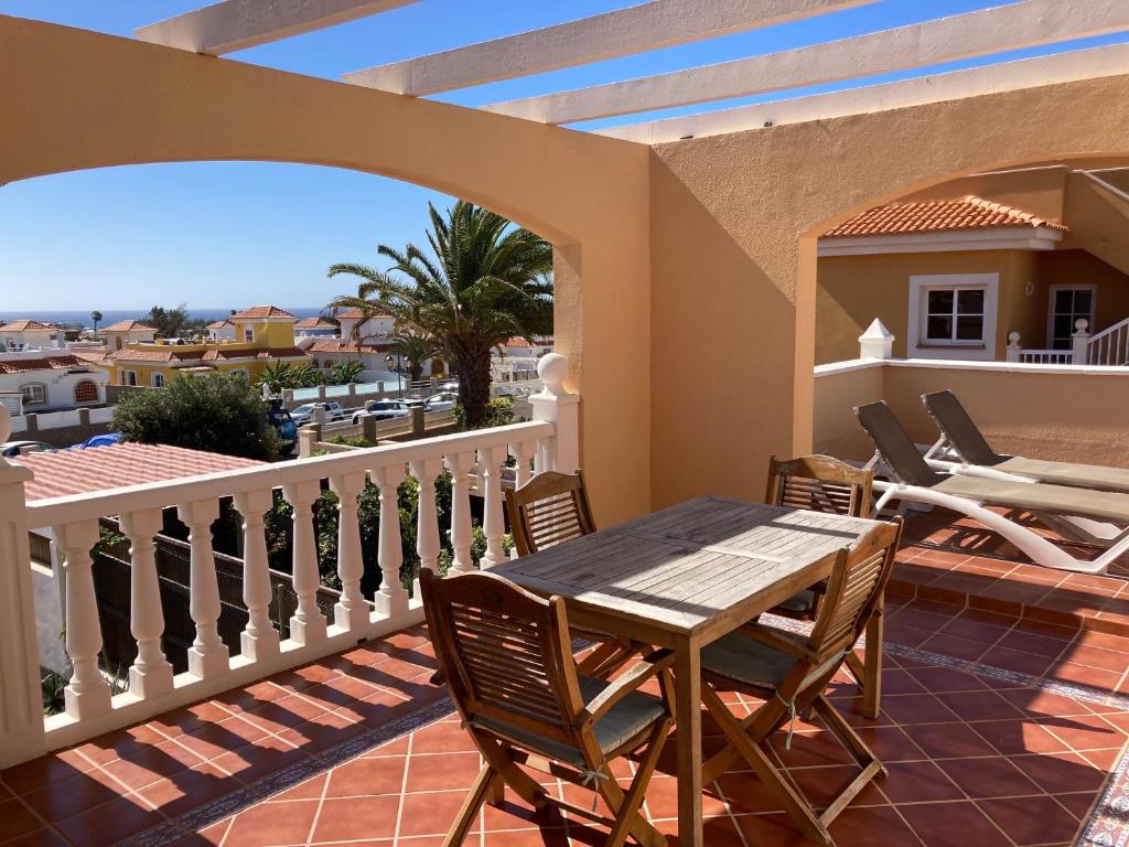 卡勒达德福斯特Las Rocas Golf and Sea的阳台的天井配有桌椅