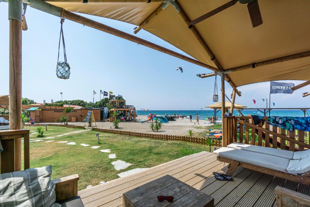 塞奥洛戈斯LOGOS Beach Village的一个带长凳的甲板,享有海滩美景