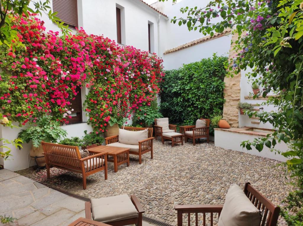 科尔多瓦ALHAJAS DE CORDOBA的一座带椅子和鲜花的庭院