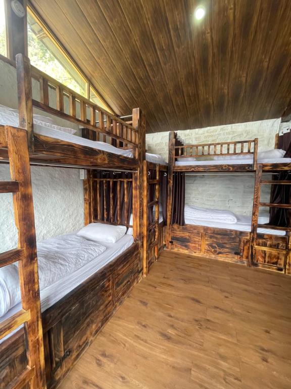 卡索尔Parvatis Lap Luxury Hostel & Camps的小屋内带三张双层床的客房