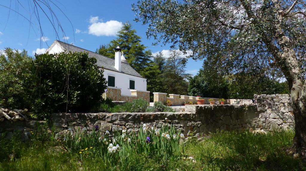 马丁纳弗兰卡TrulliMonaci的白色的房子,有石墙和鲜花