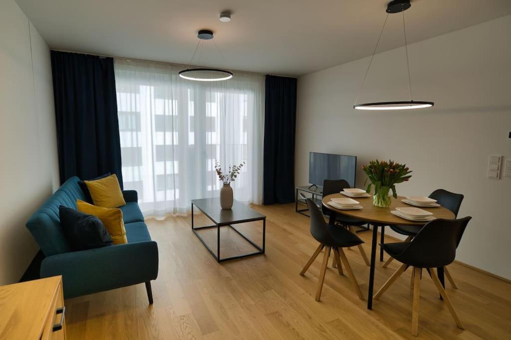 维也纳Modern apartment near Stadtpark的客厅配有桌子和蓝色沙发