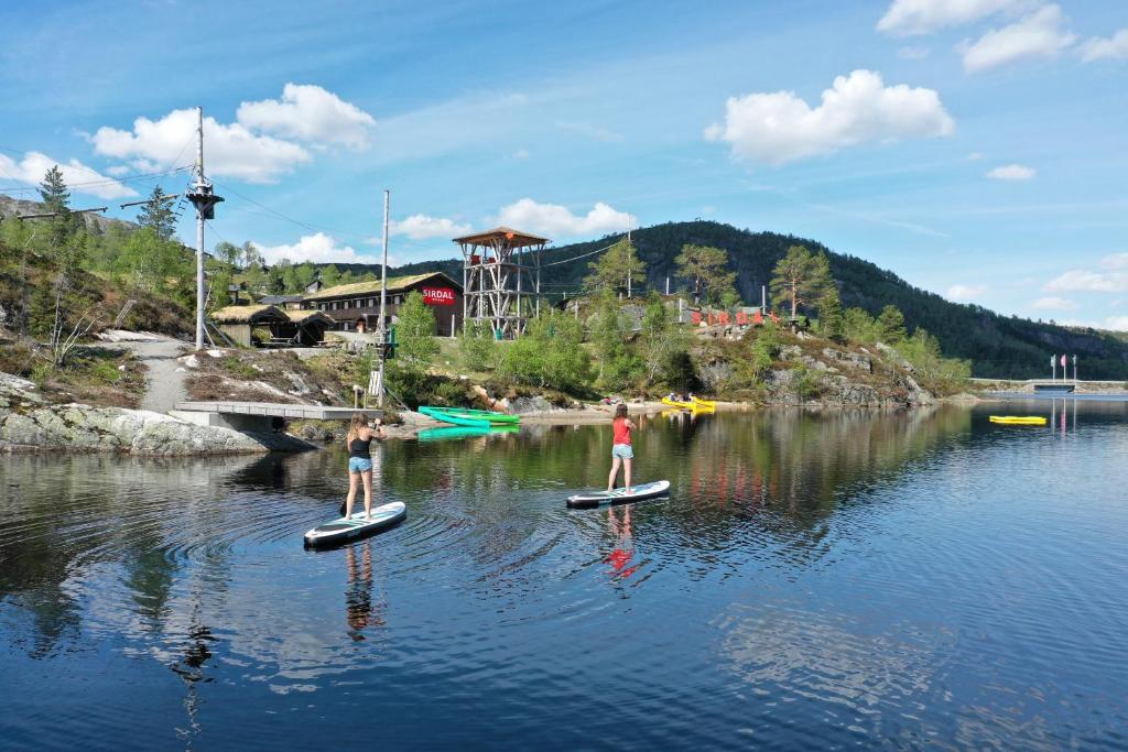 TjørhomSirdal fjellpark的两个人站在水中的桨板上
