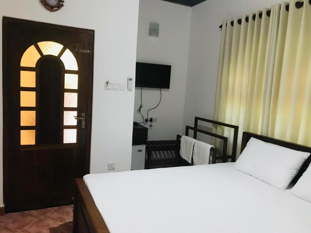 阿努拉德普勒Langama Thena - ළඟම තැන的一间卧室设有床、窗户和门