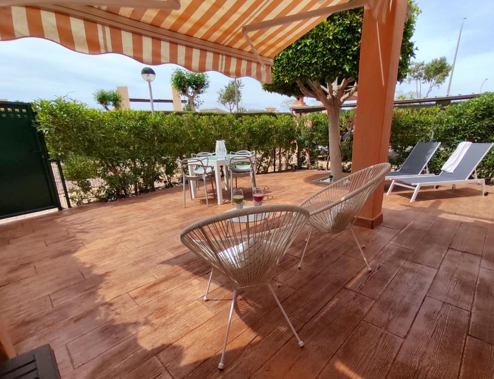 维拉VERALID Gran terraza, Wi Fi y AC en Puerto Rey的露台配有椅子和桌子,甲板上配有桌子