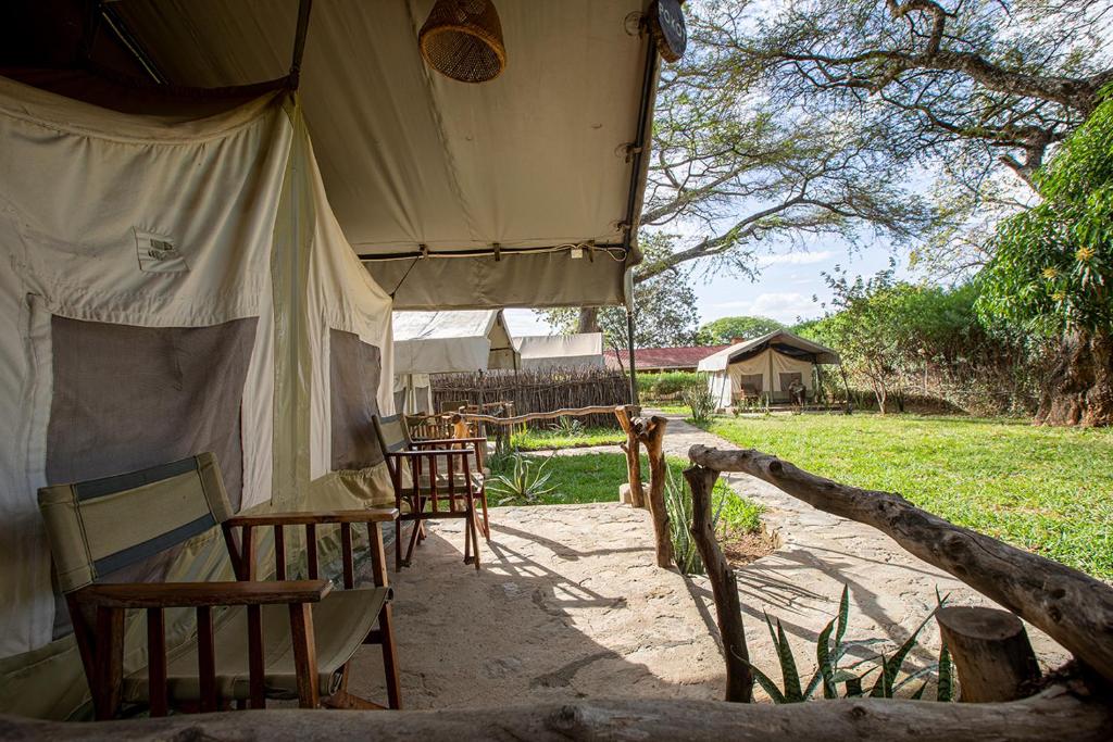MorotoKara-Tunga Safari Camp的田野上带桌椅的帐篷