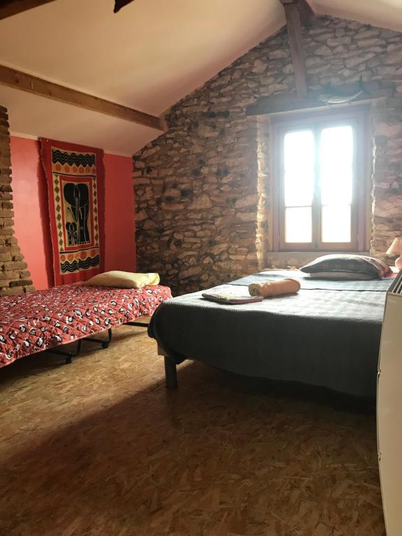 Saint-SeverChambre chez l'habitant Corail cuisine et sdb partagées的一间卧室设有两张床和石墙