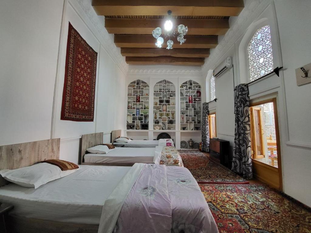 布哈拉Bobo Haydar Guest House的一间卧室设有四张床和吊灯。