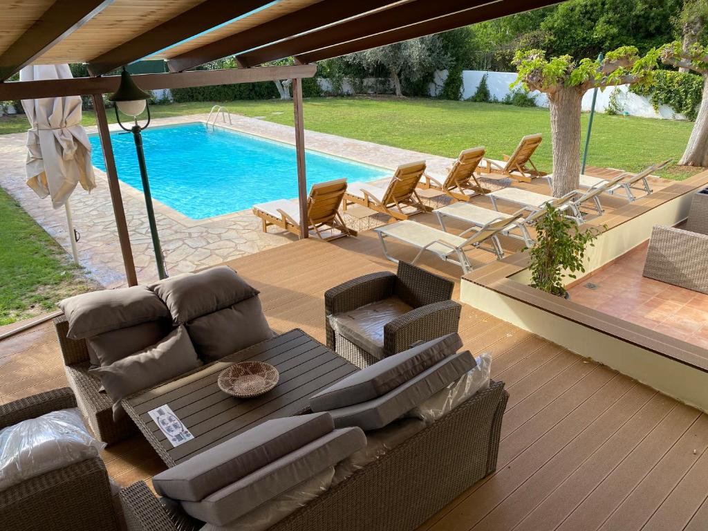 Áyios YeóryiosRelaxing Villa with Swimming Pool and Garden的带沙发的庭院和游泳池