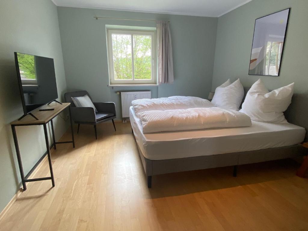卑尔根Bayern Lodge Bergen的一间卧室配有一张床、一张桌子和一把椅子