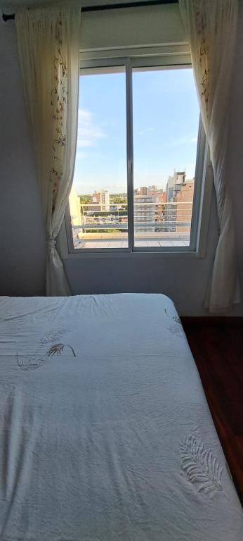 罗萨里奥departamento TEO的一间卧室设有一张床和一个大窗户