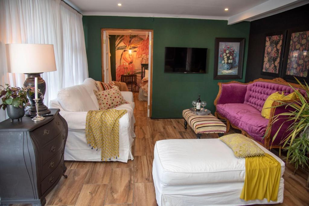 克尼斯纳La Lupa Nera的客厅配有紫色沙发和白色椅子